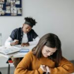 Two students concentrating on their work in a cozy classroom environment.